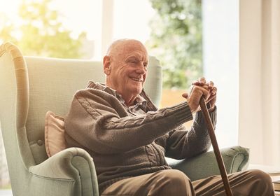 Un grand-père assis sur son fauteuil entrain de sourire