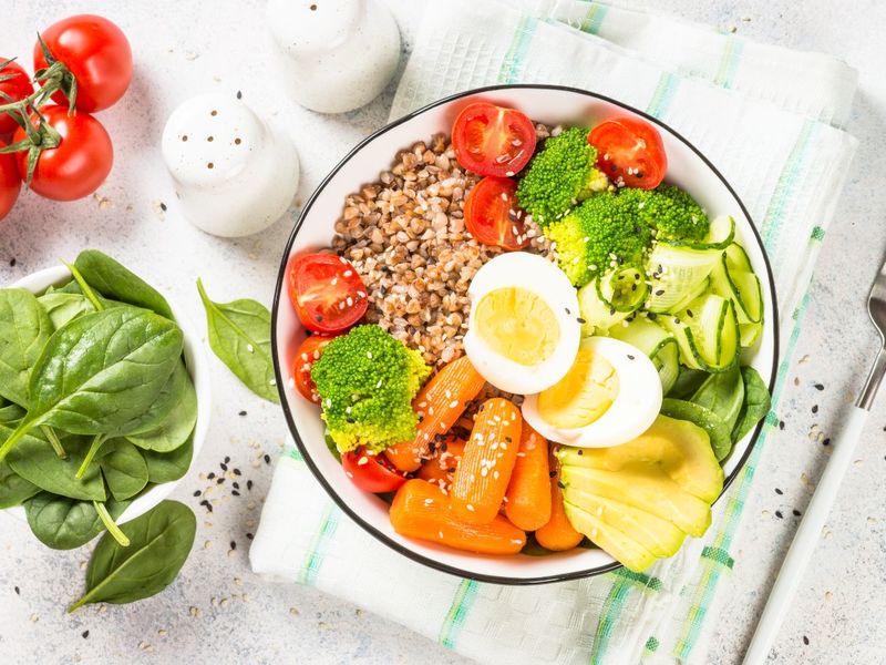 Une assiette avec une salade pleine de légumes de toutes les couleurs