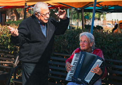Une femme âgée et un homme âgée chantant et dansant pour la fête de la musique