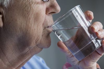 Une mamie entrain de boire un verre d'eau