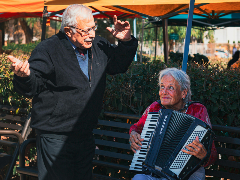Une femme âgée et un homme âgée chantant et dansant pour la fête de la musique