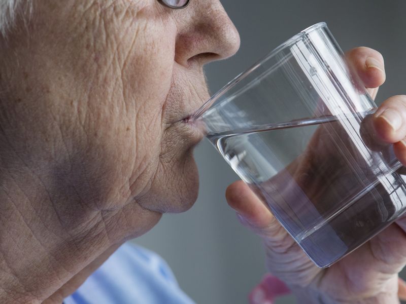 Une mamie entrain de boire un verre d'eau