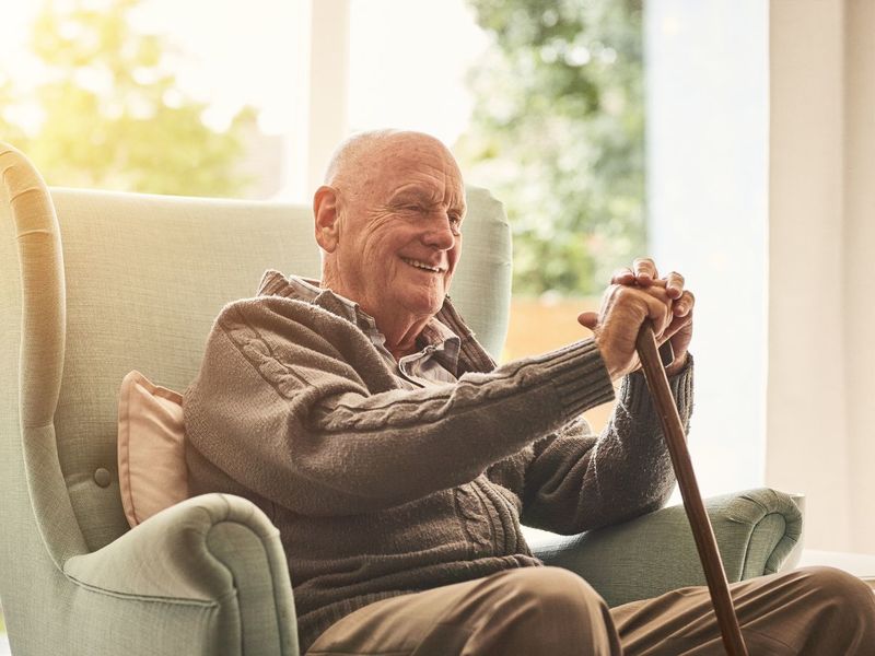 Un grand-père assis sur son fauteuil entrain de sourire