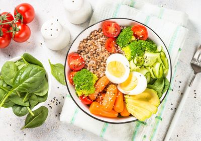 Une assiette avec une salade pleine de légumes de toutes les couleurs